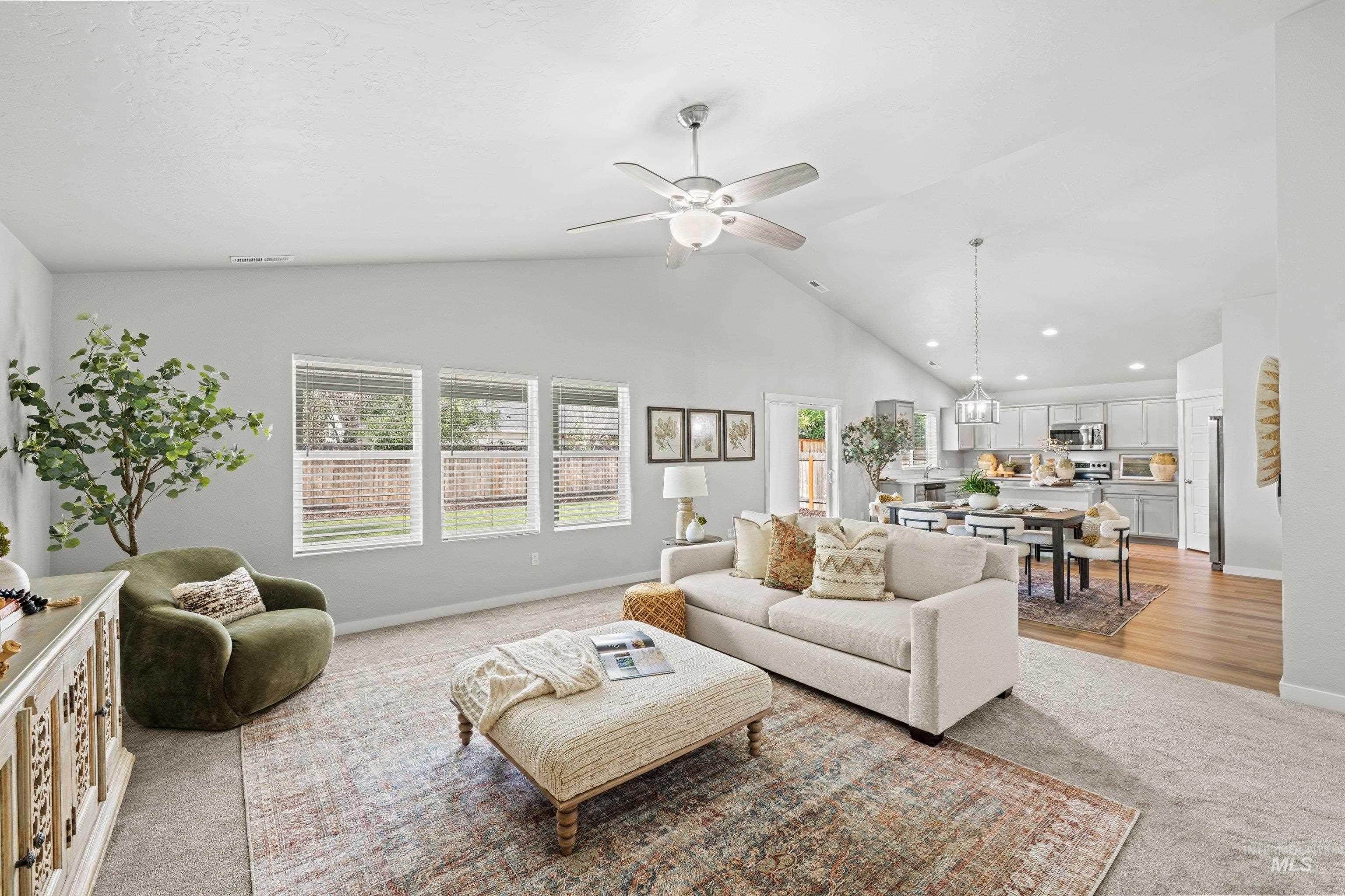 12744 West Fig Street Boise, ID 83713 - Photo 10 of 34 Vaulted ceiling living area featuring light gray walls, carpet flooring, and a ceiling fan