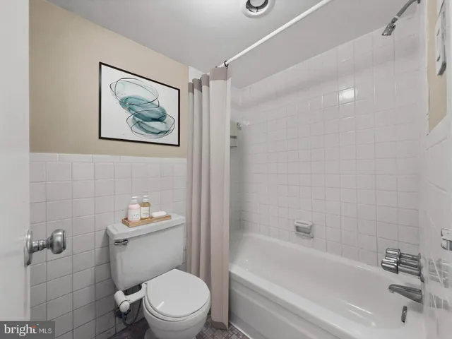 a white toilet sitting next to a bath tub