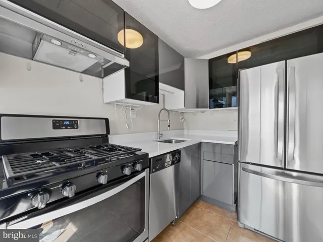 a kitchen with stainless steel appliances a stove a refrigerator and a sink