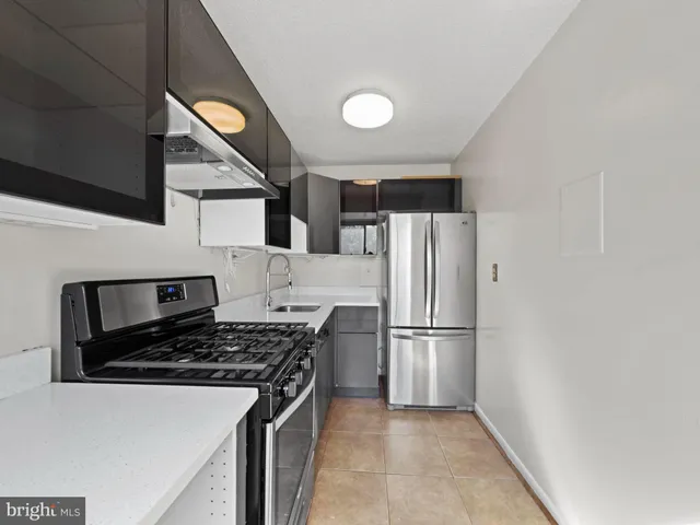a kitchen with a refrigerator and a stove top oven