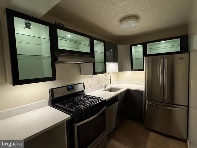a kitchen with stainless steel appliances granite countertop a refrigerator and a sink