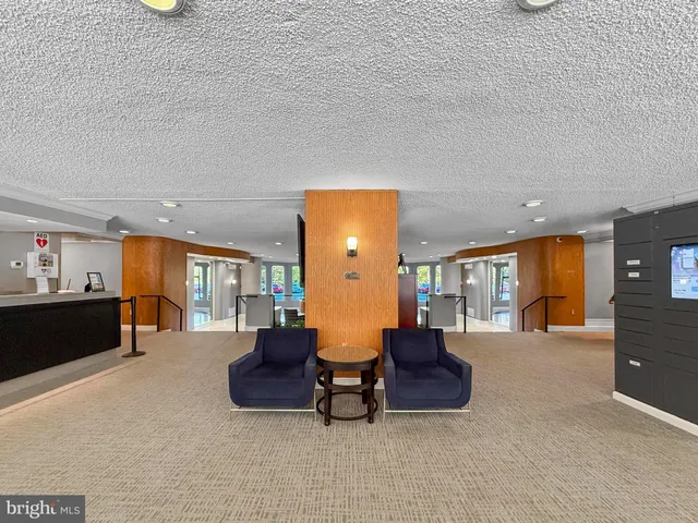 a living room with couches and kitchen view with wooden floor