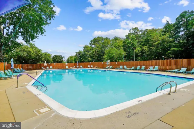 a view of a swimming pool with a yard and seating space