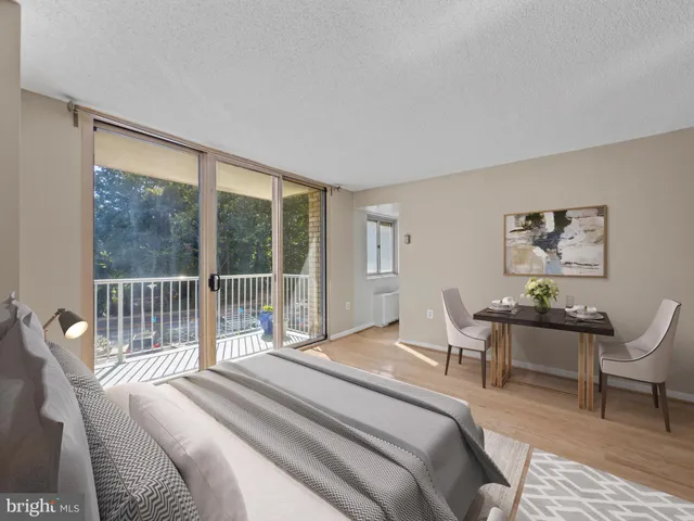 a bedroom with a bed a large window and chair