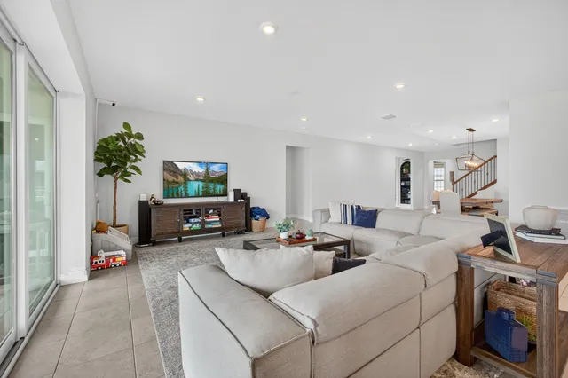 a kitchen with stainless steel appliances granite countertop a stove a refrigerator a sink a dining table and chairs with wooden floor