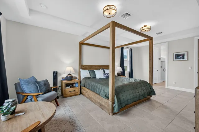 a bedroom with a bed and a large window with the outer view