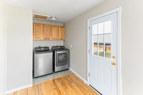 a view of a kitchen with white cabinets and wooden floor