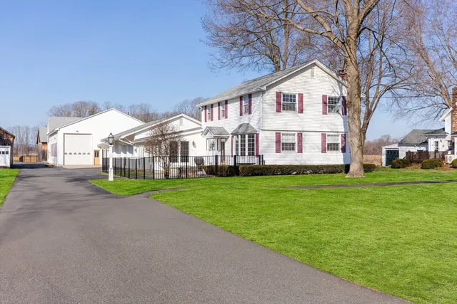a view of a big house with a big yard and large trees