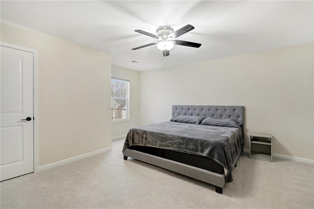 310 Coppergate Court Canton, GA 30115 - Photo 18 of 32 a spacious bedroom with a bed and window