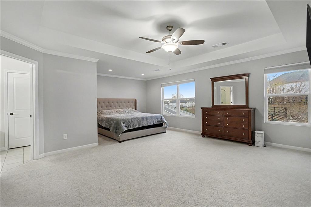 310 Coppergate Court Canton, GA 30115 - Photo 23 of 32 a spacious bedroom with a bed and a chandelier