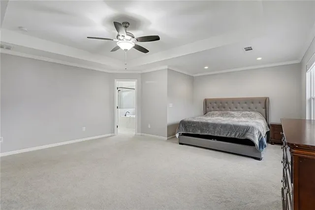 a spacious bedroom with a bed and a ceiling fan