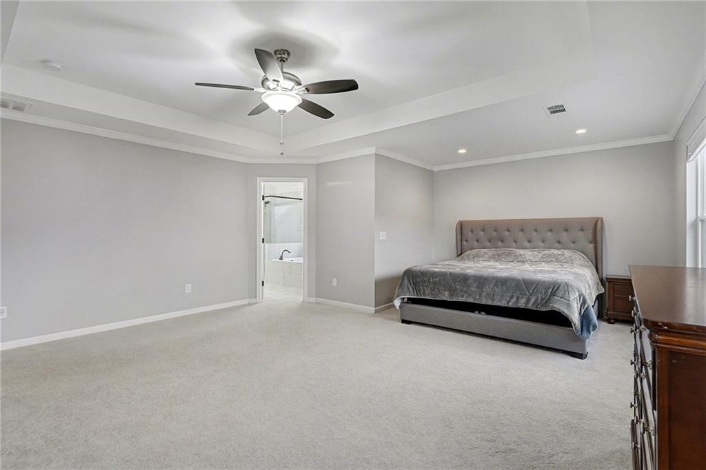 310 Coppergate Court Canton, GA 30115 - Photo 24 of 32 a spacious bedroom with a bed and a ceiling fan