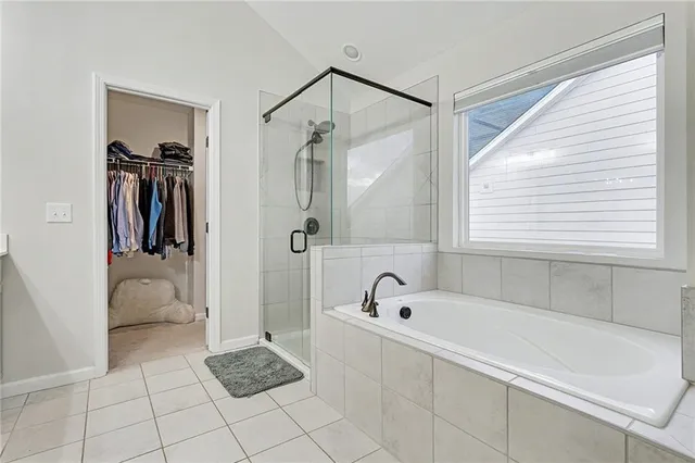 a bathroom with a tub a window and a shower