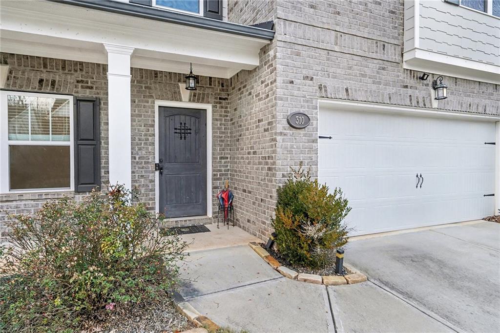 310 Coppergate Court Canton, GA 30115 - Photo 3 of 32 a potted plant sitting in front of a house