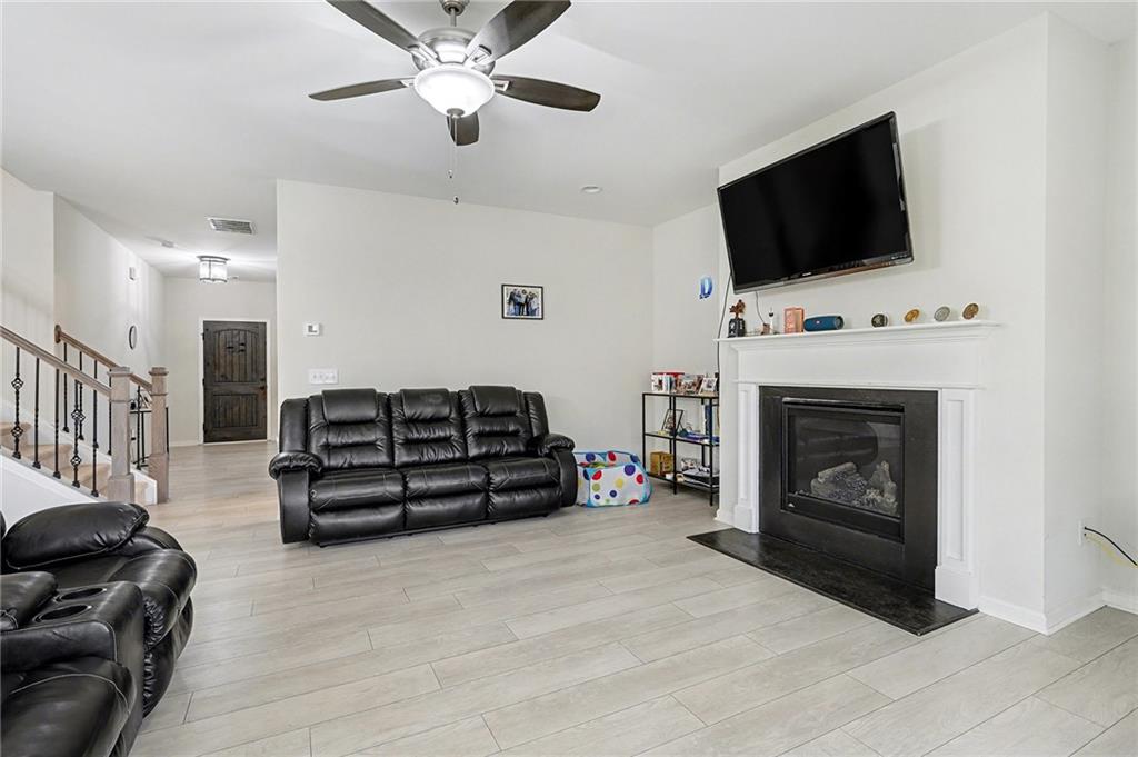 310 Coppergate Court Canton, GA 30115 - Photo 5 of 32 a living room with furniture a flat screen tv and a fireplace