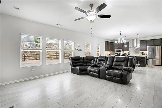 a living room with furniture kitchen view and a large window