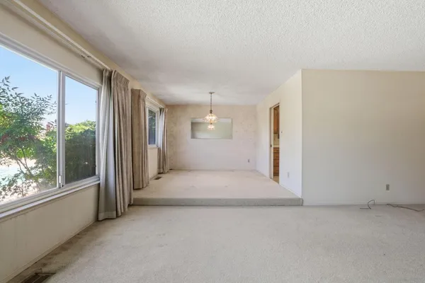 a large kitchen with stainless steel appliances granite countertop a sink dishwasher a stove a dining table and chairs with wooden floor