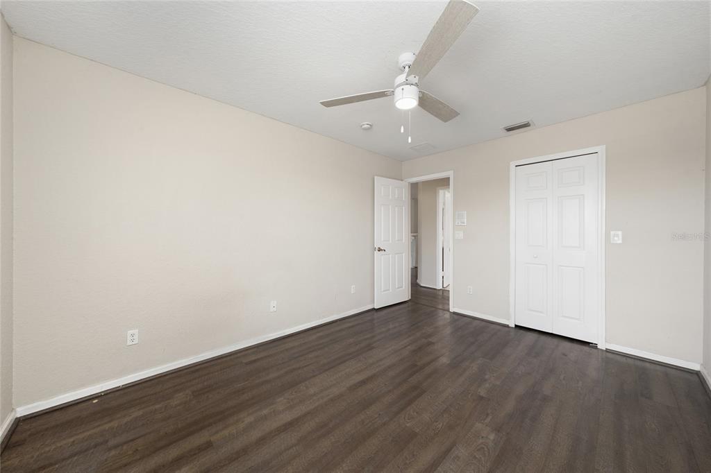 2962 White Cedar Circle Kissimmee, FL 34741 - Photo 16 of 24 an empty room with wooden floor and ceiling fan