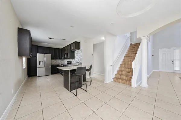a kitchen with stainless steel appliances kitchen island granite countertop a refrigerator and a sink