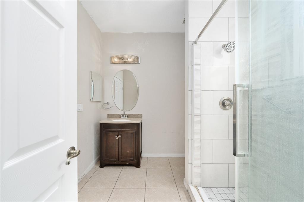 2962 White Cedar Circle Kissimmee, FL 34741 - Photo 10 of 24 a bathroom with a granite countertop sink a mirror and bathtub