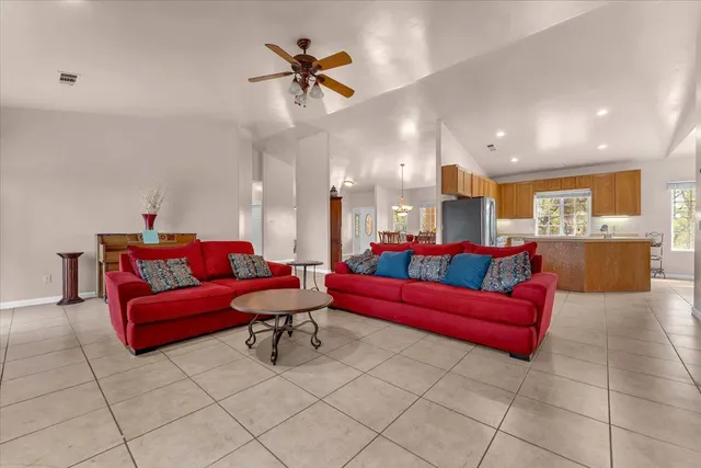 a living room with furniture and a dining table with kitchen view