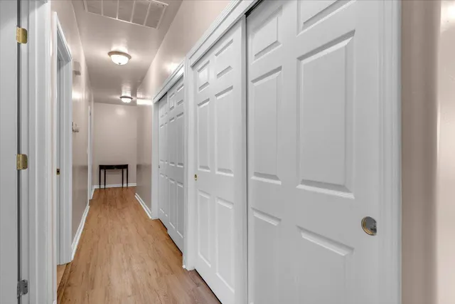 a view of a hallway with wooden floor and staircase