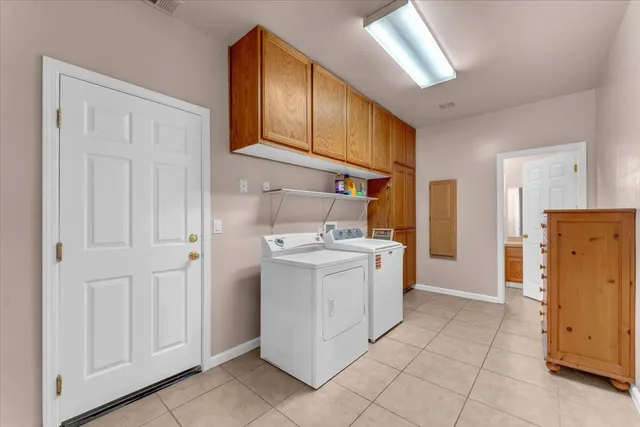 a utility room with cabinets washer and dryer