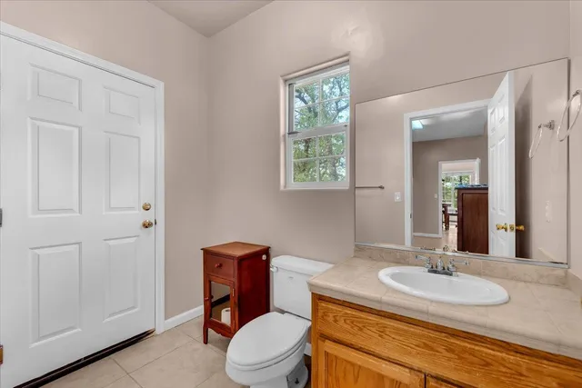 a bathroom with a granite countertop toilet sink and mirror