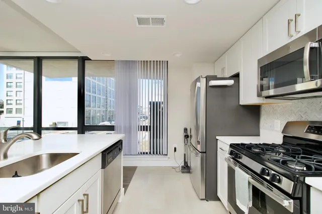 a kitchen with stainless steel appliances a sink dishwasher stove microwave and cabinets