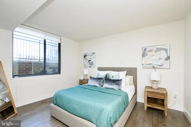 a bedroom with a bed and a painting on the wall