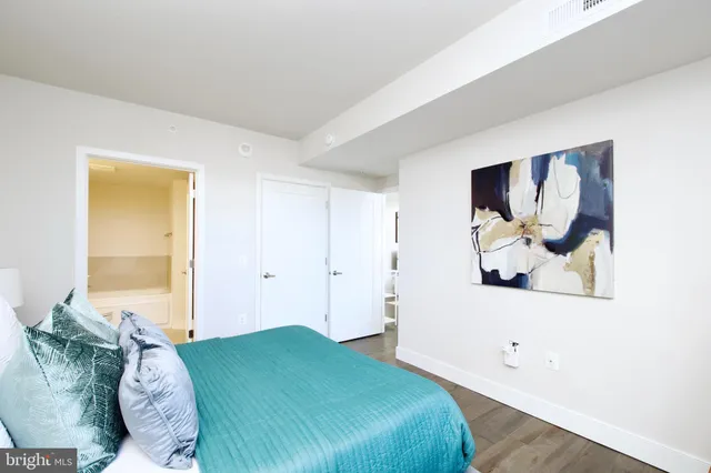 a bedroom with a bed and a painting on the wall