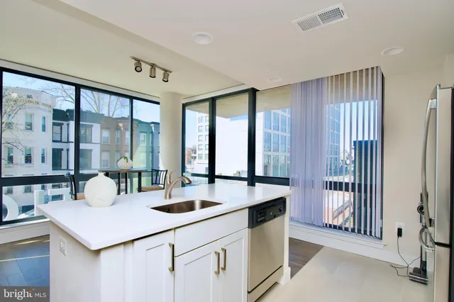 a kitchen with stainless steel appliances a stove microwave and refrigerator