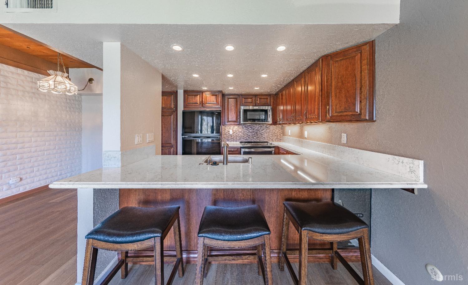 439 Ala Wai Boulevard, Unit 121 South Lake Tahoe, CA 96150 - Photo 6 of 35 a kitchen with stainless steel appliances granite countertop a table chairs sink and cabinets