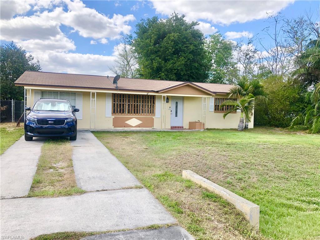 19 Massachusetts Road Lehigh Acres, FL 33936 - Photo 1 of 20 a front view of a house with a garden and lake view