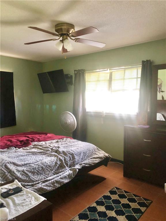 19 Massachusetts Road Lehigh Acres, FL 33936 - Photo 11 of 20 a bedroom with a bed and a window