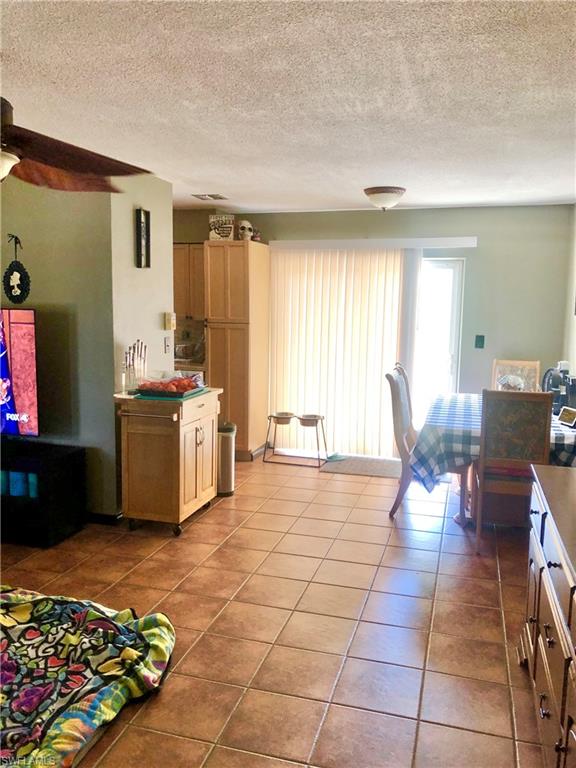 19 Massachusetts Road Lehigh Acres, FL 33936 - Photo 6 of 20 a view of a kitchen with kitchen island stainless steel appliances a stove a sink a rug and a dining table chair
