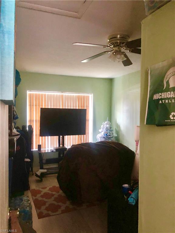 19 Massachusetts Road Lehigh Acres, FL 33936 - Photo 10 of 20 a bedroom with a bed and a chandelier