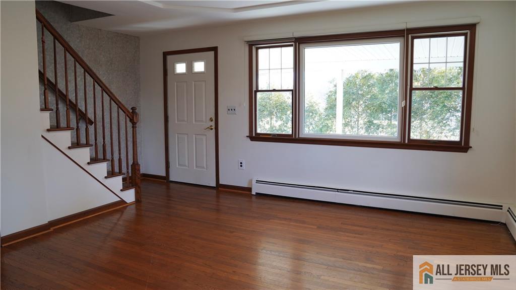226 Gravel Hill Road Monroe Township, NJ 08831 - Photo 5 of 9 an empty room with wooden floor and windows