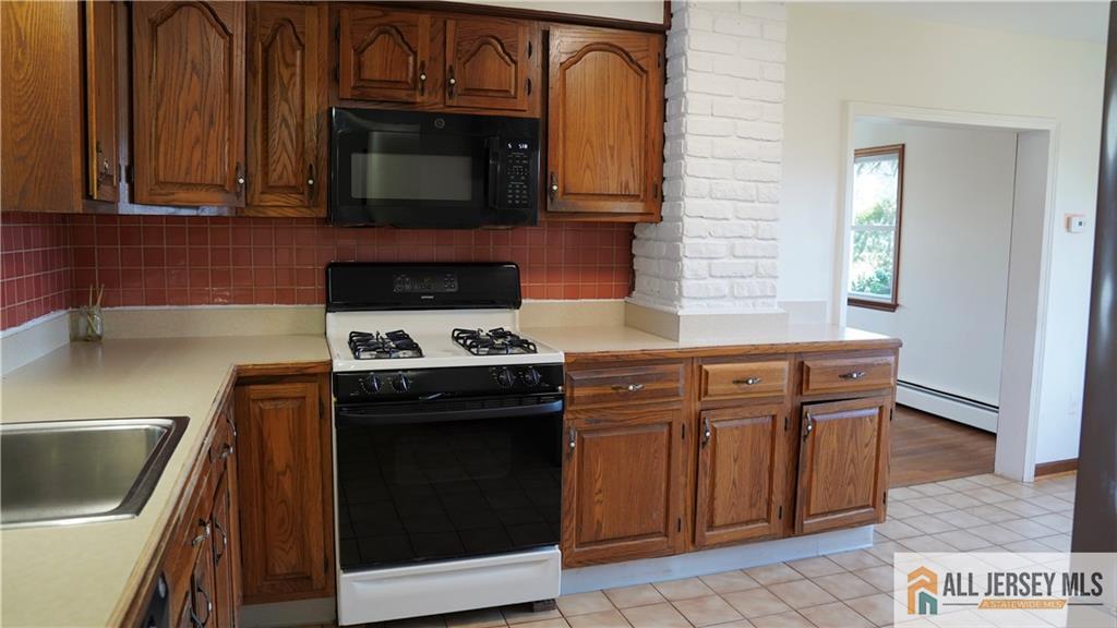 226 Gravel Hill Road Monroe Township, NJ 08831 - Photo 6 of 9 a kitchen with granite countertop a stove top oven microwave and cabinets