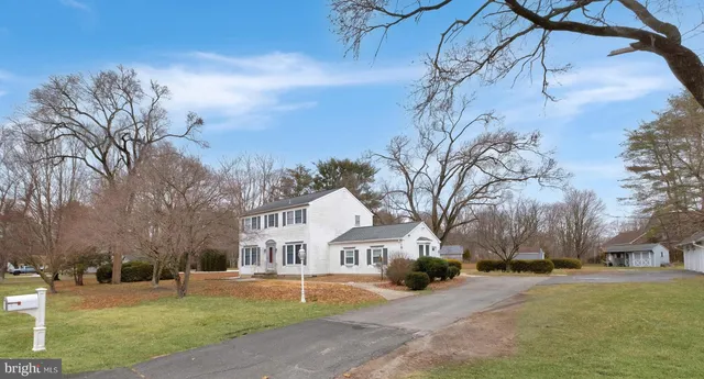 a front view of a house with a yard and covered with snow