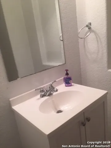 a bathroom with a sink vanity and a mirror