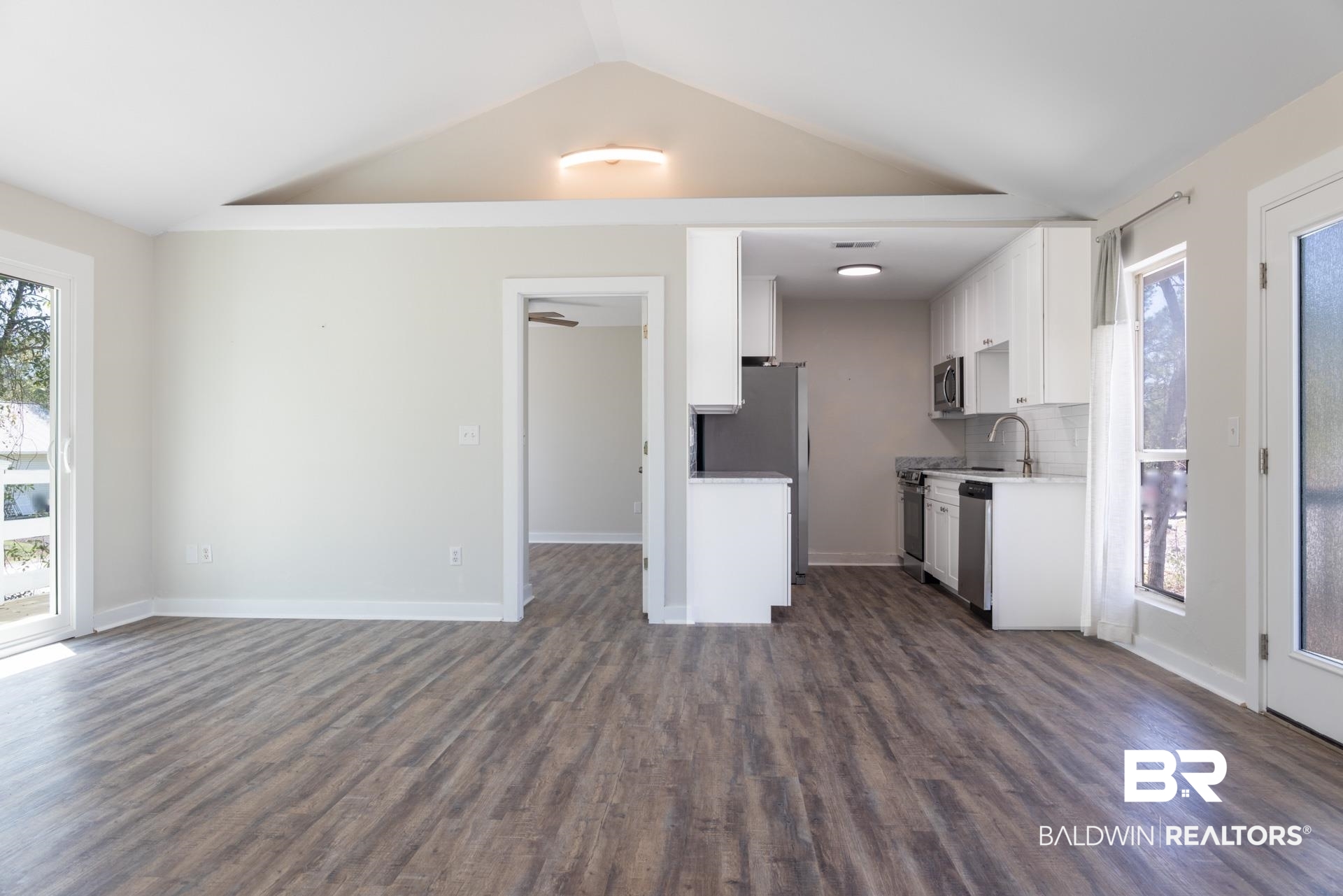 413 West Fort Morgan Road Gulf Shores, AL 36542 - Photo 29 of 29 Kitchen with decorative backsplash, white cabinetry, open floor plan, and appliances with stainless steel finishes