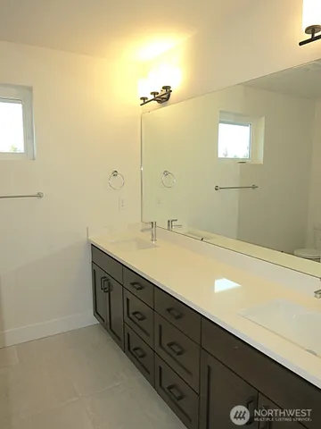 a bathroom with a double vanity sink and a mirror