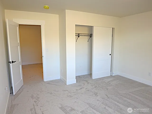 an empty room with closet and a bathroom