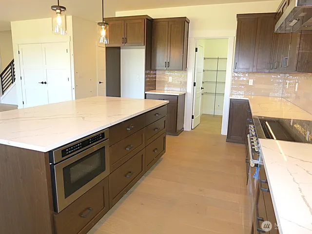 a kitchen with stainless steel appliances kitchen island granite countertop a stove a sink and a refrigerator