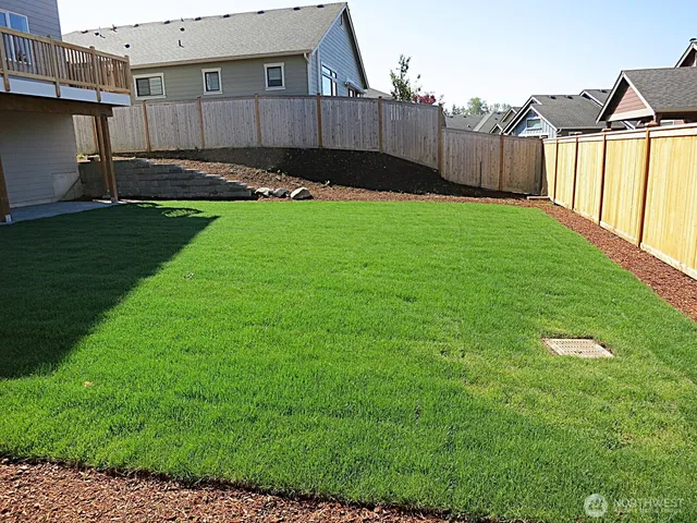a view of a backyard with a small cabin and wooden fence