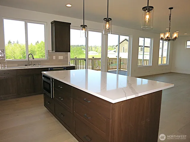a kitchen with stainless steel appliances a sink a large window and wooden floor