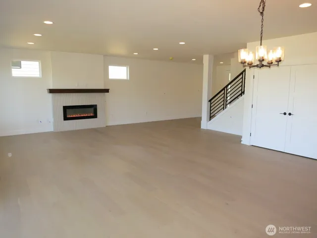 a view of a livingroom with a fireplace a chandelier and a projector