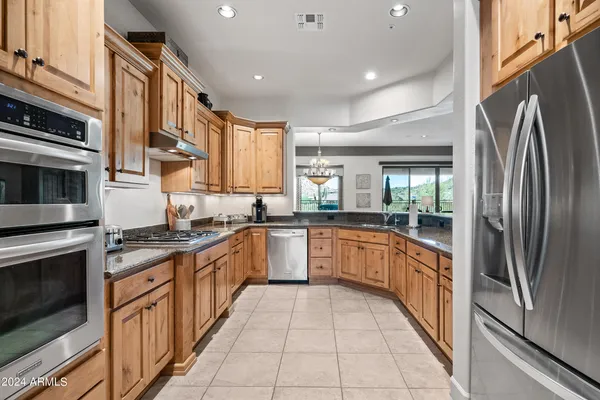a kitchen with stainless steel appliances granite countertop a refrigerator and a stove top oven