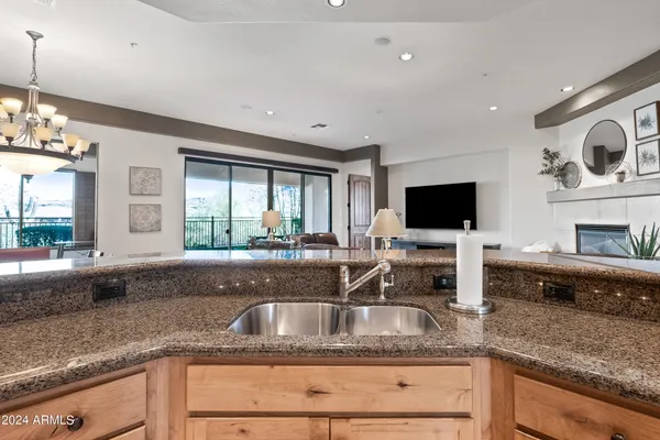 a dining room with wooden floor a chandelier a wooden table and chairs